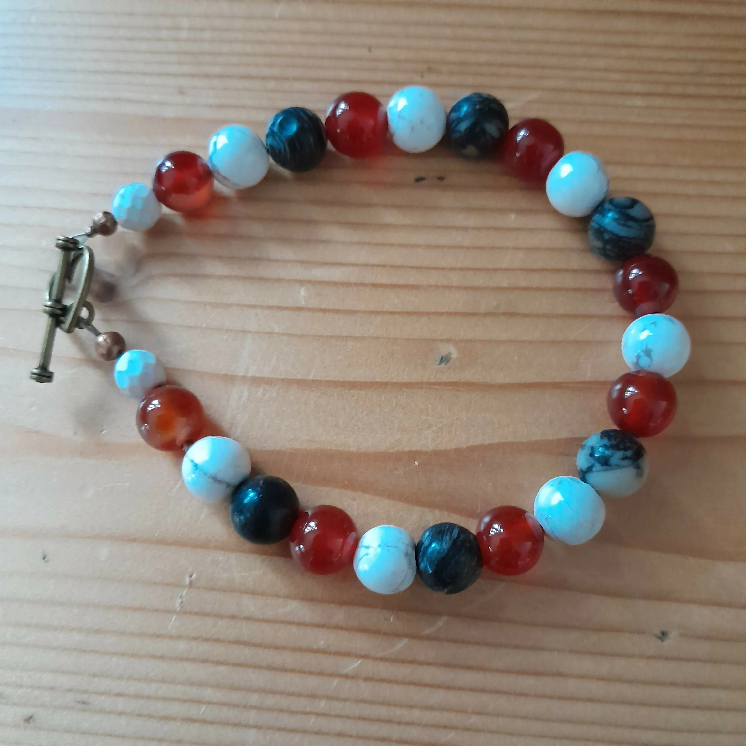 Bronze Toggle Catch Bracelet with Faceted Howlite, Carnelian, Polished Howlite and Black Silkstone.